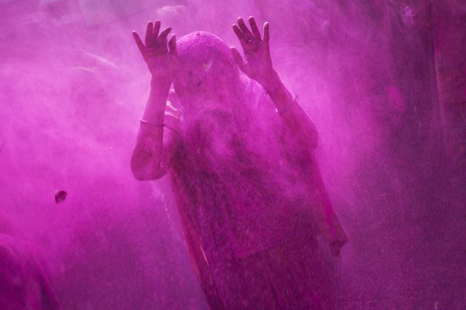 A widow raises her hands as others throw colored powder on her during celebrations in Vrindavan on March 3.
