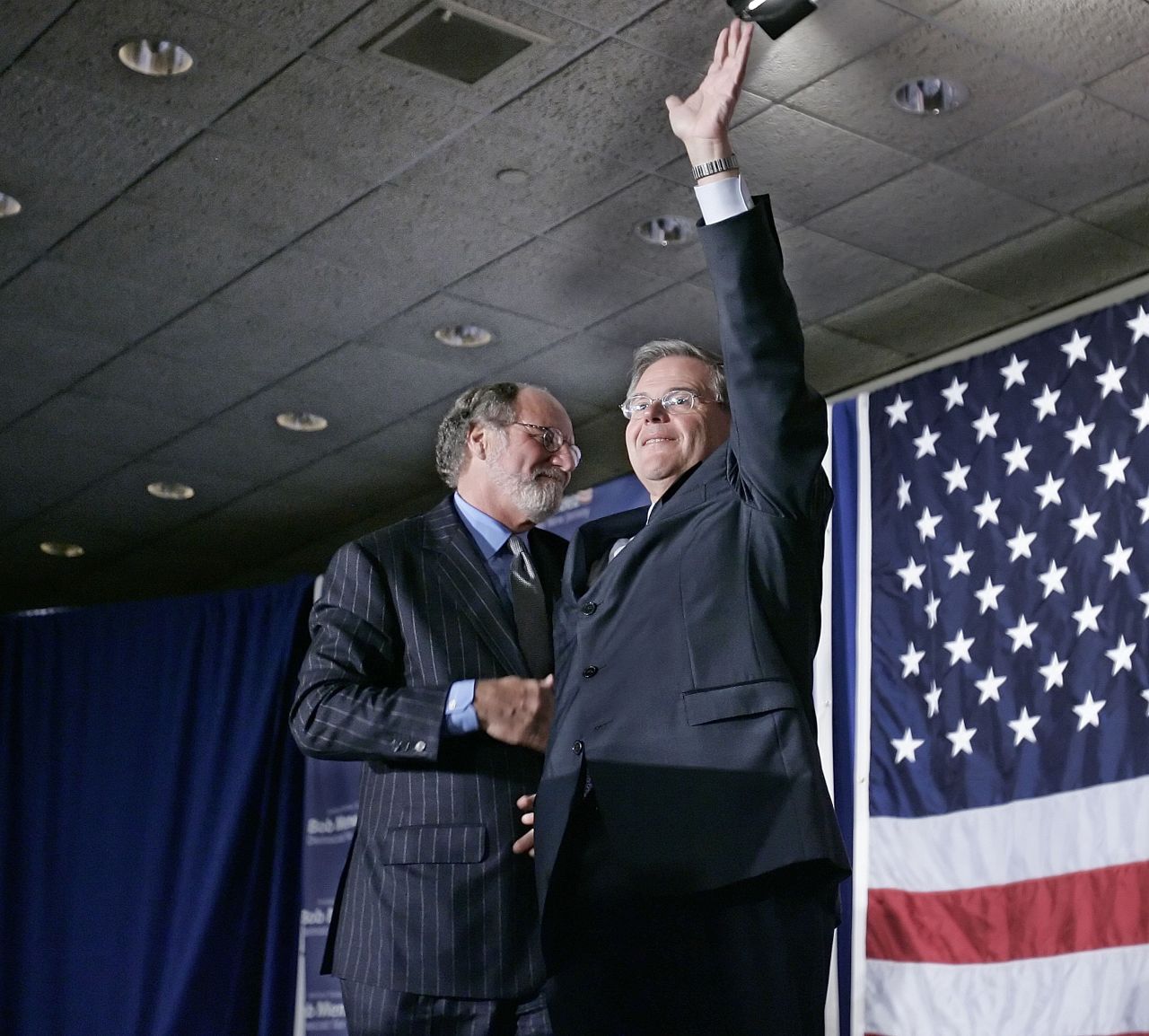 Sen. Robert Menendez (D-NJ) waves to the crowd with New Jersey Gov. Jon Corzine at his side at election night headquarters after Menendez defeated Republican challenger Thomas Kean Jr., November 7, 2006 in East Brunswick, New Jersey.