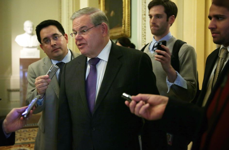 Sen. Robert Menendez talks to reporters as he arrives at the weekly Senate Democratic Policy Committee luncheon March 25, 2014 at the Capitol in Washington.