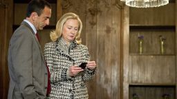 Then-Secretary of State Hillary Clinton looks at a phone message with Assistant Secretary Philip Gordon in 2012.