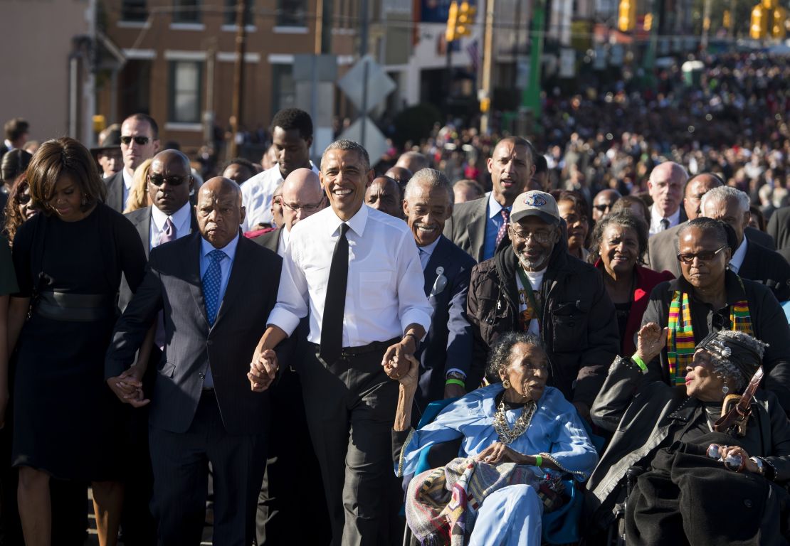 President Barack Obama walks alongside US Representative John Lewis (2nd-L), Democrat of Georgia, and other original marchers, across the Edmund Pettus Bridge to mark the 50th Anniversary of the Selma to Montgomery civil rights marches in Selma, Alabama, March 7, 2015. 