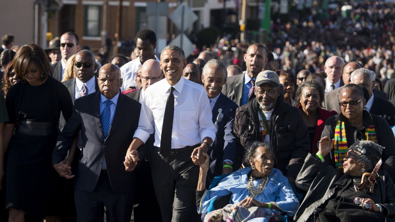 President Barack Obama walks alongside US Representative John Lewis (2nd-L), Democrat of Georgia, and other original marchers, across the Edmund Pettus Bridge to mark the 50th Anniversary of the Selma to Montgomery civil rights marches in Selma, Alabama, March 7, 2015.