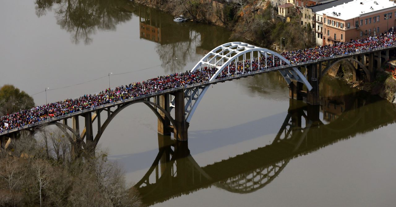 Crowds of people move in a symbolic walk across the bridge on March 8. 
