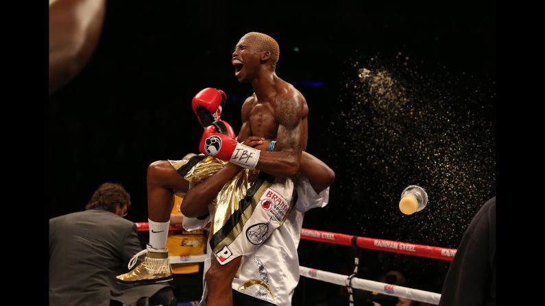 A drink is thrown as Zolani Tete, the IBF super flyweight champion, celebrates his title defense over Paul Butler on Saturday, March 7. Tete stopped Butler in the eighth round of the fight, which took place in Liverpool, England.
