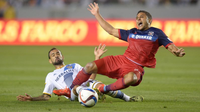 Chicago Fire forward Quincy Amarikwa, right, is tackled by Los Angeles Galaxy midfielder Juninho during the MLS season opener Friday, March 6, in Carson, California. The Galaxy, last season's champions, won the match 2-0.