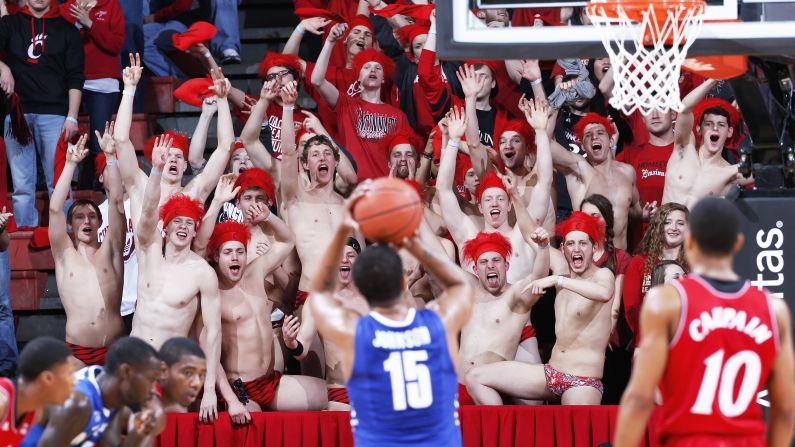 Members of the Cincinnati Bearcats' swim team try to distract a free-throw attempt by Memphis' Kedren Johnson during a college basketball game Sunday, March 8, in Cincinnati. 