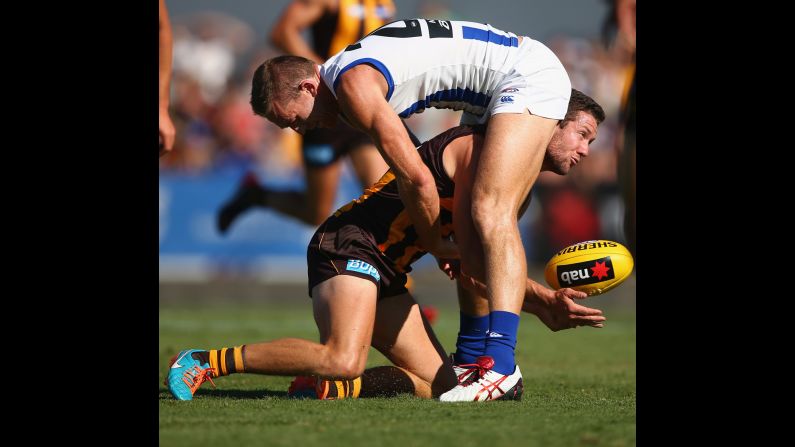 Drew Petrie of the North Melbourne Kangaroos, top, challenges James Frawley of the Hawthorn Hawks during an Australian Football League match Sunday, March 8, in Shepparton, Australia.
