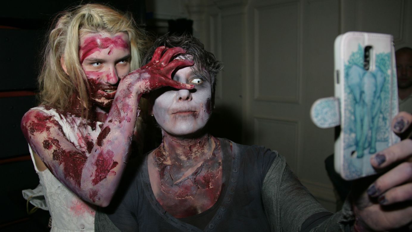 People dressed as zombies take a selfie Saturday, March 7, at the Windsor Zombie Walk in Windsor, England.