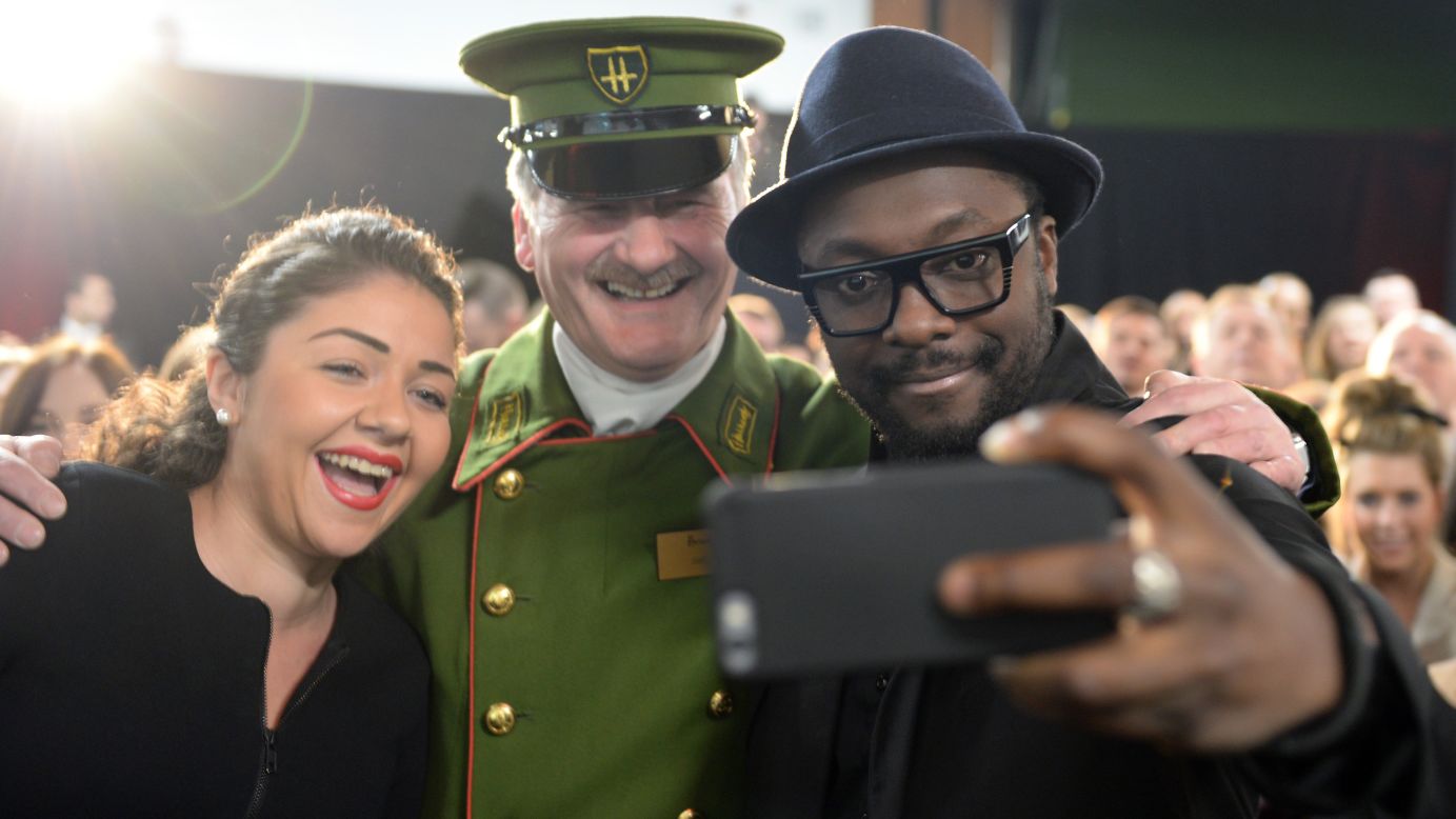 Musician will.i.am, right, surprised staff at the Harrods department store in London on Thursday, March 5.
