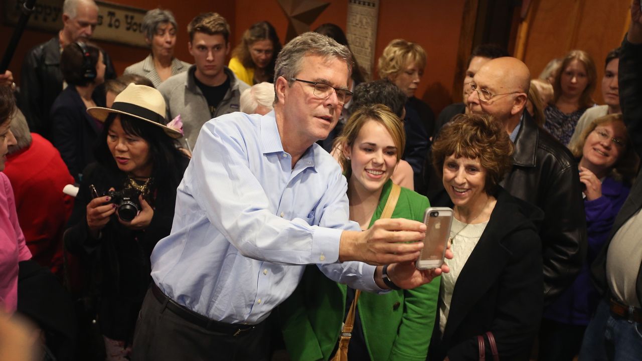 Former Florida Gov. Jeb Bush takes a selfie with Iowa residents after speaking at a restaurant in Cedar Rapids, Iowa, on Saturday. March 7.