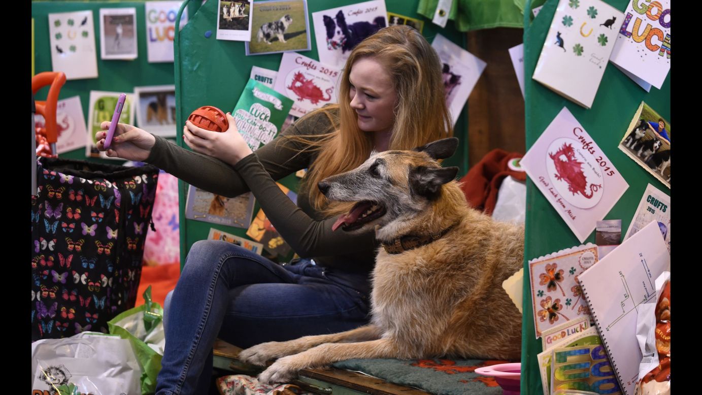Emily George takes a photo with her Belgian shepherd, Byre, during the Crufts dog show in Birmingham, England, on Thursday, March 5.