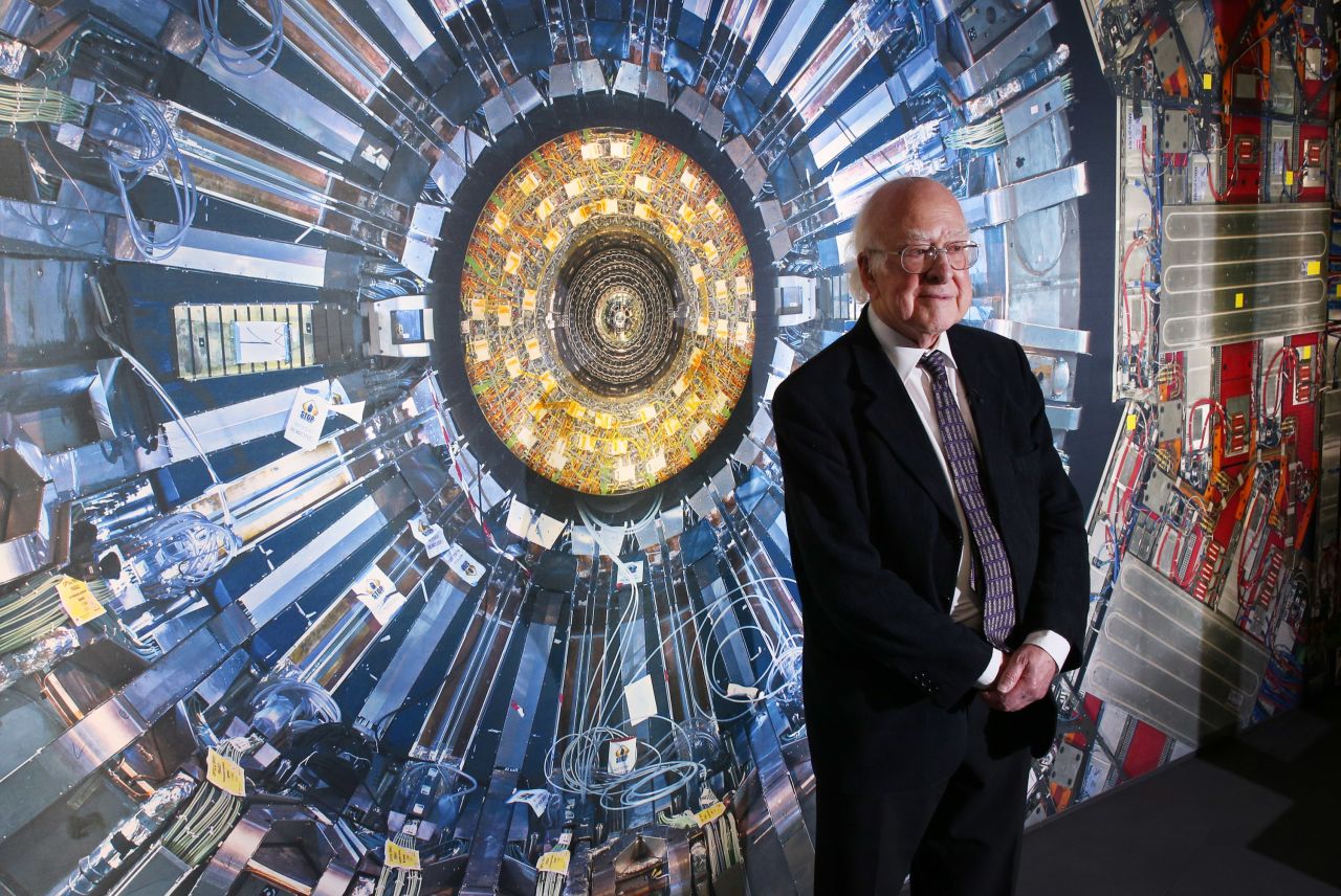 Professor Peter Higgs, who gives his name to the Higgs boson, stands in front of an image of the collider. Having nailed down the elusive boson particle in 2013, physicists are on the trail of the dark matter. 