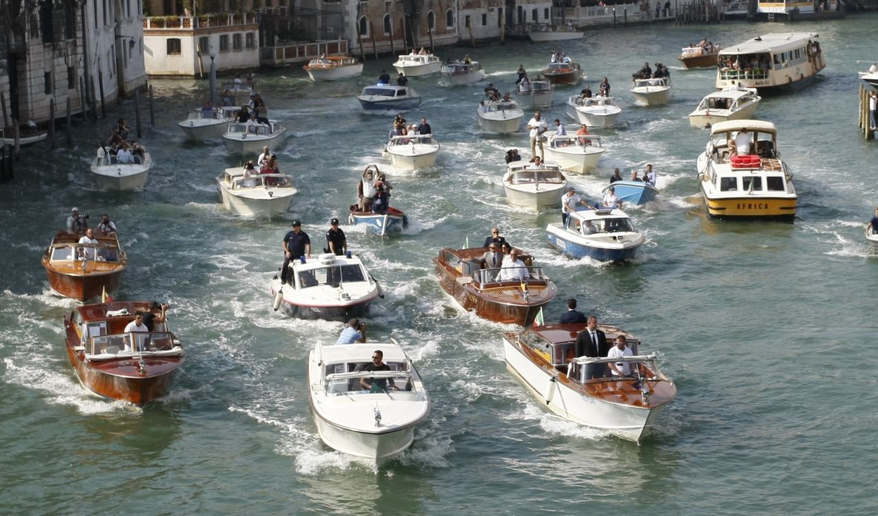 Boats surround the taxi boat of George Clooney and his wife, Amal Alamuddin Clooney, in September 2014 on the Grand Canal in Venice. 