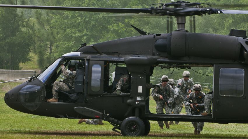 Rangers make their way to the UH-60 Blackhawk to exit the area during a scenario at the 6th Ranger Training Battalion's annual open house event, May 12 at Eglin Air Force Base, Fla. The event was a chance for the public to learn how Rangers train and operate. The event displays showed dive equipment, weapons, a reptile zoo and zodiac boats among others. The demonstrations showed off hand-to-hand combat, a parachute jump, a down-pilot scenario and others. (U.S. Air Force photo/Samuel King Jr.)