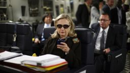 In this Oct. 18, 2011, file photo, then-Secretary of State Hillary Rodham Clinton checks her Blackberry from a desk inside a C-17 military plane upon her departure from Malta, in the Mediterranean Sea, bound for Tripoli, Libya.