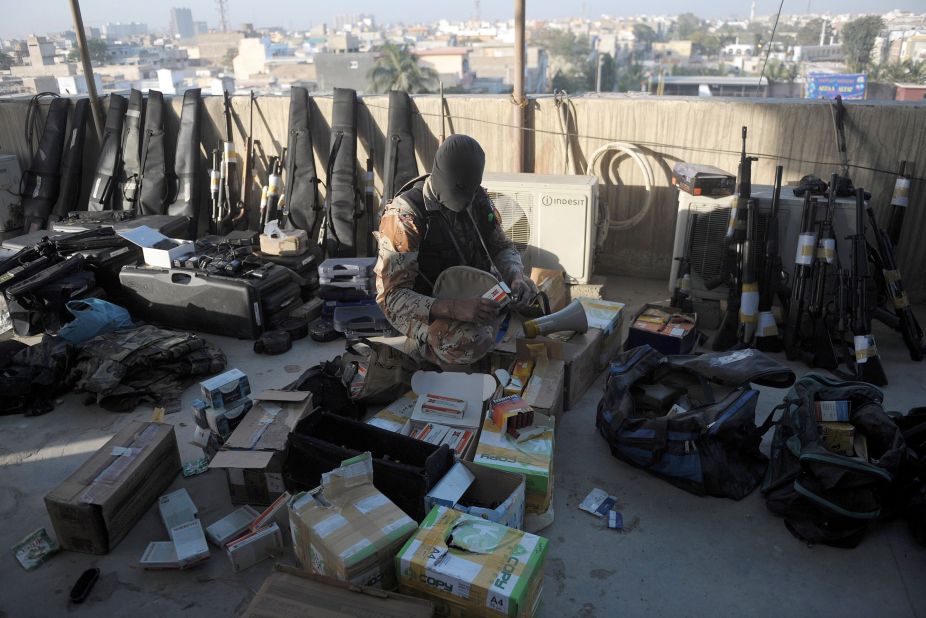 A Pakistani paramilitary soldier inspects weapons recovered after Rangers raided Muttahida Qaumi Movement (MQM) offices in Karachi. 
