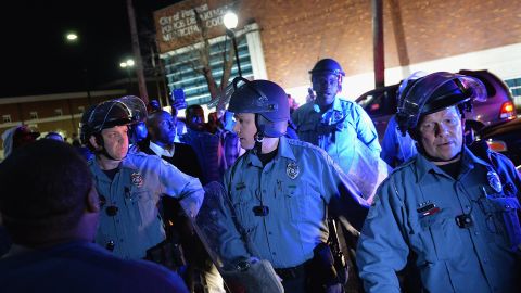 Police in riot gear respond to demonstrators blocking traffic in Ferguson on March 11.