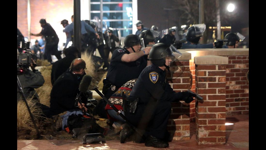Police take cover after the two officers were shot on March 12.