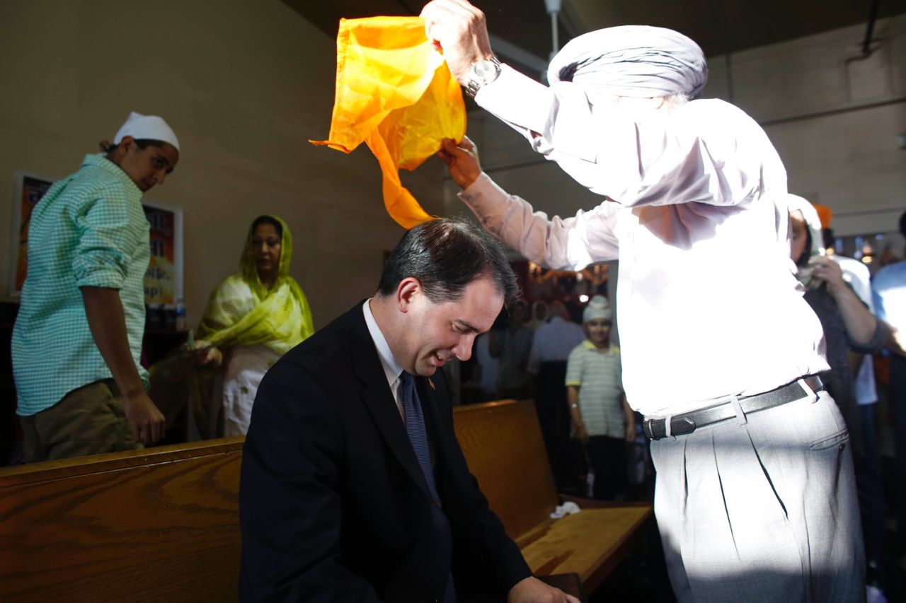 Walker has a scarf put on his head during a special service at the Sikh Religious Society of Wisconsin for the victims of the shooting at the Sikh Temple of Wisconsin the previous day, on August 6, 2012, in Brookfield, Wisconsin.