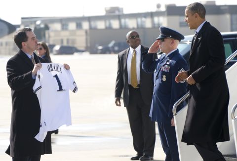 President Barack Obama receives a Milwaukee Brewers baseball jersey from Walker (left) as he disembarks from Air Force One upon arrival at General Mitchell International Airport in Milwaukee, Wisconsin, February 15, 2012.