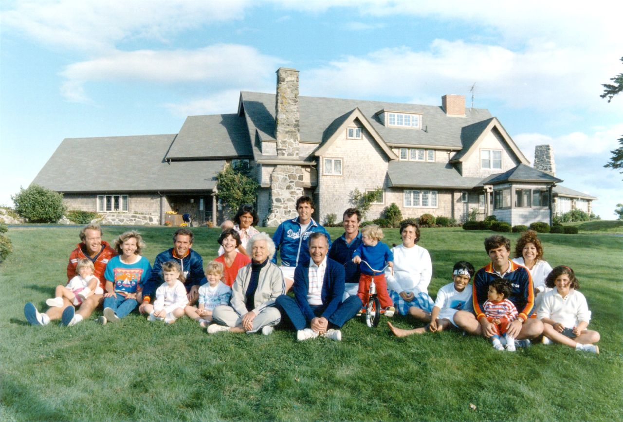 Portrait of the Bush family in front of their Kennebunkport, Maine house August 24, 1986. Pictured, back row: Margaret holding daughter Marshall, Marvin Bush, Bill LeBlond. Pictured, front row: Neil Bush holding son Pierce, Sharon, George W. Bush holding daughter Barbara, Laura Bush holding daughter Jenna, Barbara Bush, George Bush, Sam LeBlond, Doro Bush Lebond, George P. (Jeb's son), Jeb Bush holding son Jebby, Columba Bush and Noelle Bush.