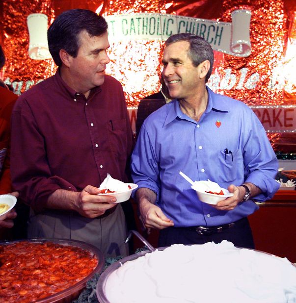 Then-President George W. Bush (right) and Jeb Bush go through the line for strawberries during a stop at the Stawberry Festival March 12, 2000 in Plant City, Florida.