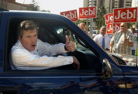 Bush gives a thumbs up signal from his car as he leaves a local polling station after casting his vote in Coral Gables, Florida, November 5, 2002.