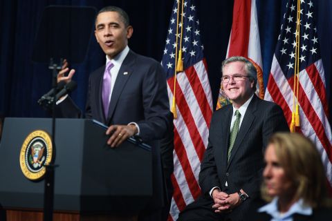 President Barack Obama (left) speaks about Bush (center) while visiting Miami Central Senior High School on March 4, 2011 in Miami, Florida. The visit focused on education.