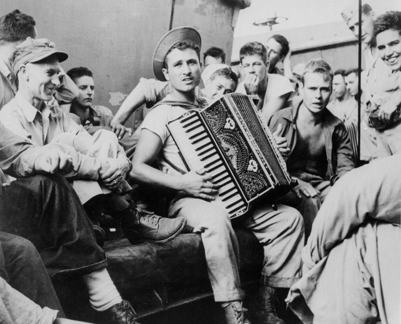 War correspondent Ernie Pyle (1900-1945, far left) observes life aboard a U.S. troopship on its way to Okinawa.