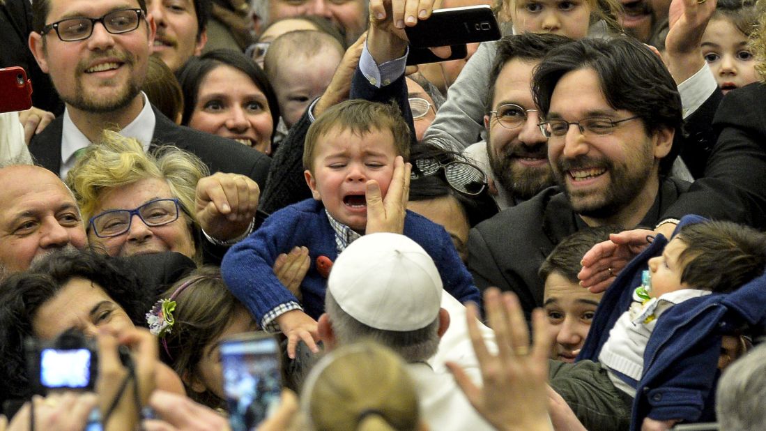 Pope Francis touches a child's face as he arrives for a meeting at the Vatican on Friday, March 6, 2015.