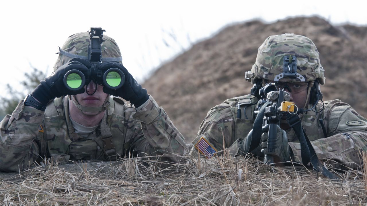 U.S. Army Pfc. William Chaput, left, and Staff Sgt. Demarcus Credit, both of Lightning Troop, 3rd Squadron, 2nd Cavalry Regiment, scan for enemy activity during a combined training exercise at Pabrades training area, March 4, 2015. 