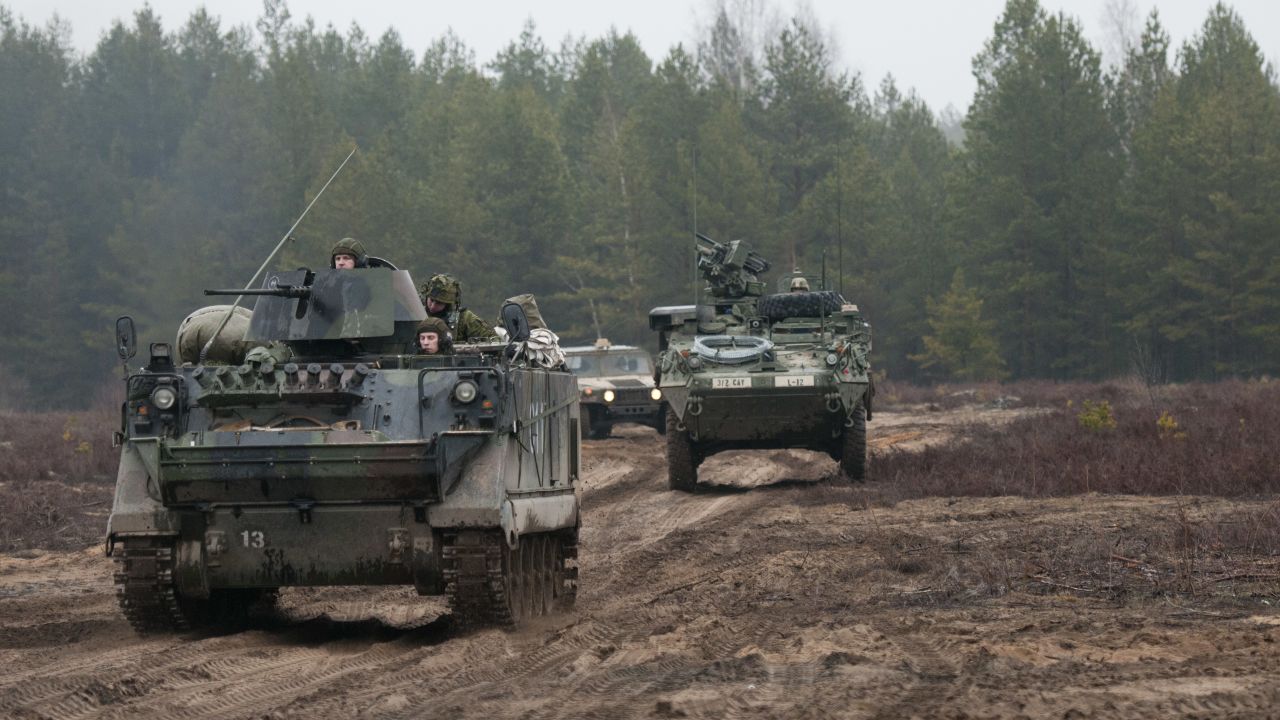 Lithuanian soldiers, left, of 3rd Company, Algirdas Mechanized Infantry Battalion, advance in a M113 armored personnel carrier with U.S. Troopers from 3rd Platoon, Lightning Troop, 3rd Squadron, 2nd Cavalry Regiment, following close behind at Pabrade Training Area, Lithuania, March 2, 2015. 