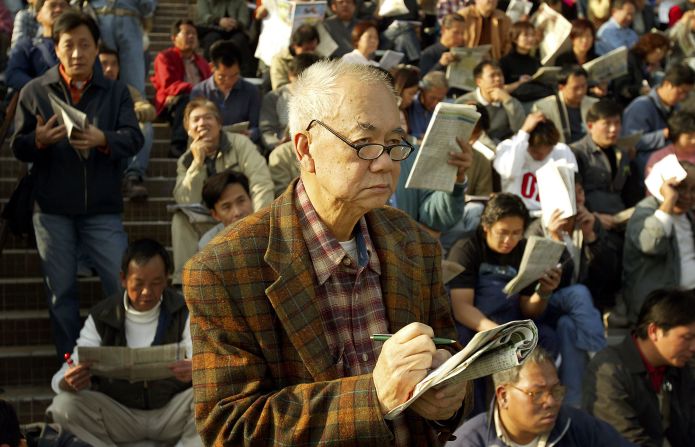 Perhaps considering the maxim, "by failing to prepare, you are preparing to fail," an elderly punter calmly ponders his racing form at the Hong Kong International Races. 