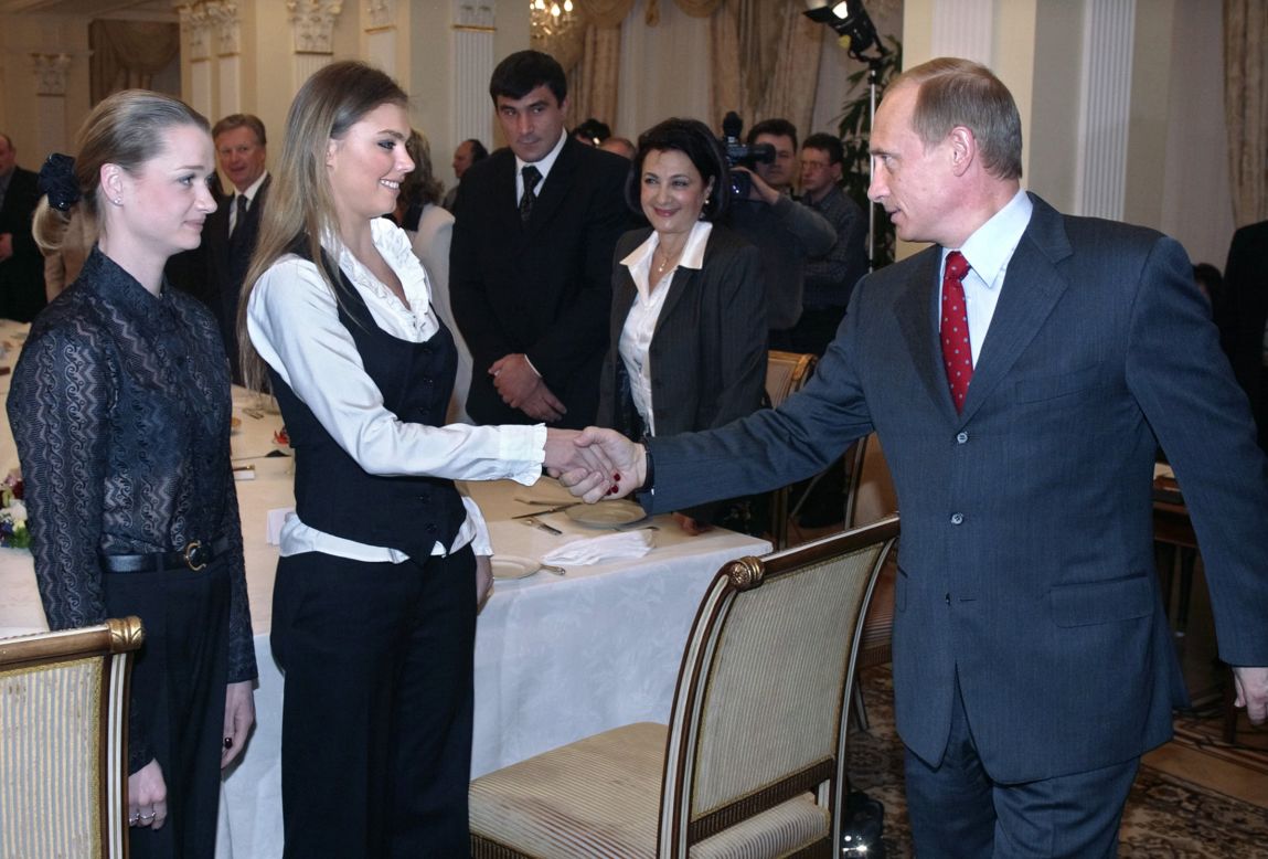 Putin shakes hands with famous Russian gymnasts Alina Kabayeva, center, and Svetlana Khorkina in March 2004.