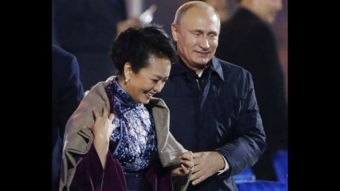Putin puts a shawl on Peng Liyuan, wife of Chinese President Xi Jinping, as they arrive to watch a fireworks show in Beijing in November. 
