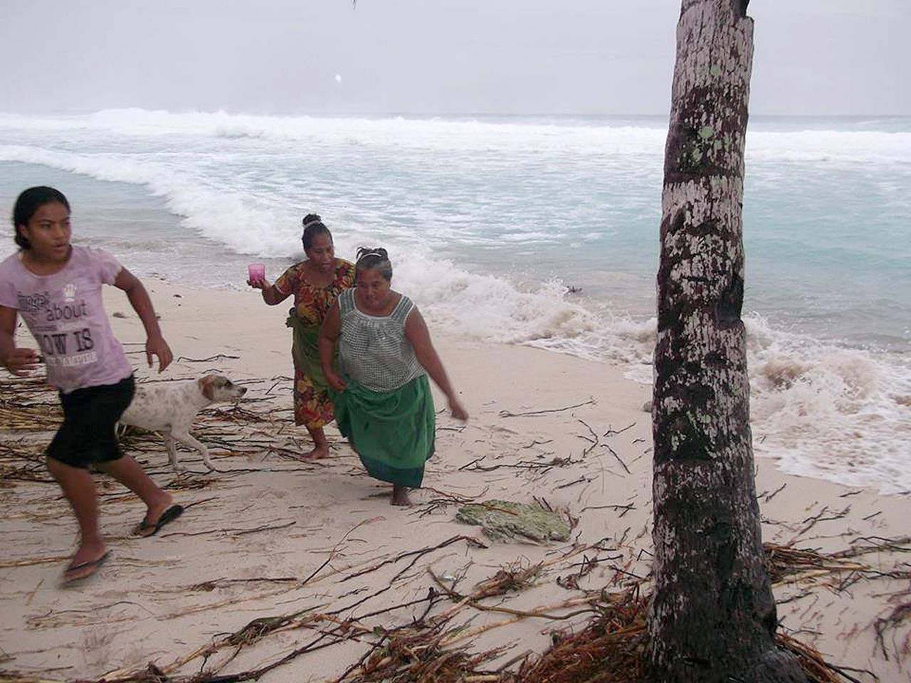 People move away from the beach March 13 on the island of Kiribati. 