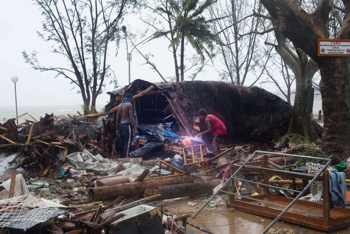Residentes observan los daños Barcos afectados por la tormenta el 14 de marzo en Port Vila.