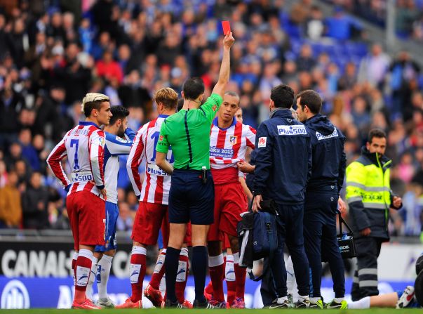 Atletico defender Joao Miranda (center) is shown a red card for a challenge on Espanyol's Abraham Gonzalez in first-half stoppage time.
