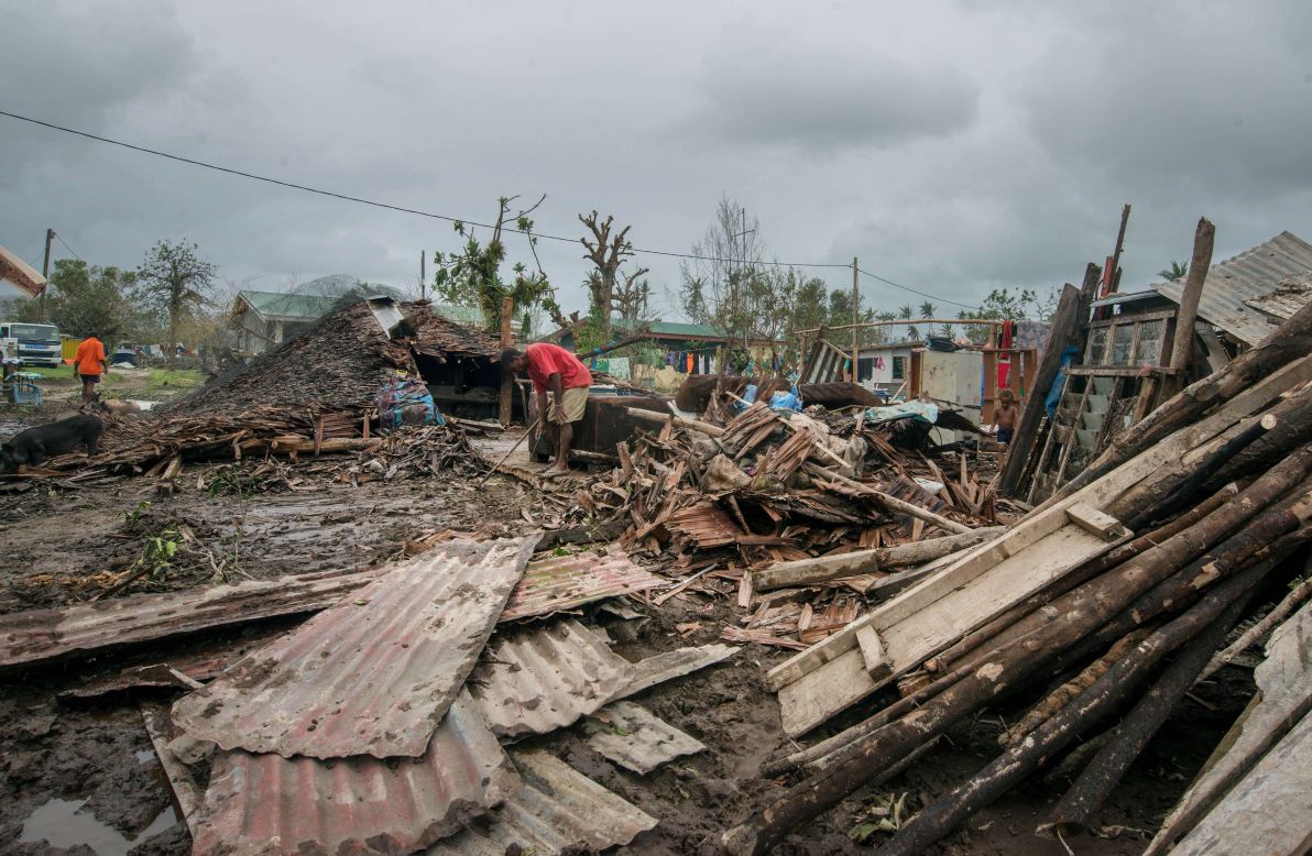 Residents work amid the debris left by the cyclone outside Port Vila on March 15. 