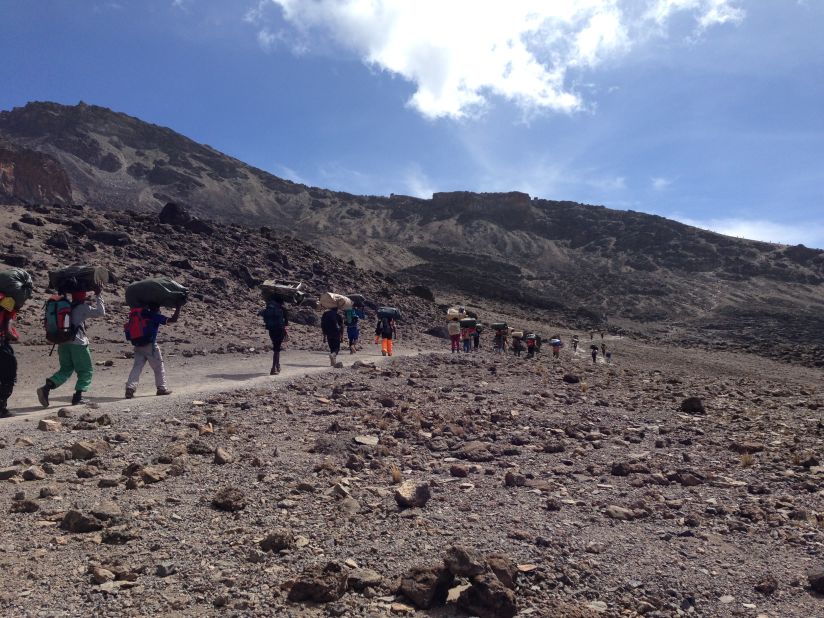 It takes a village to climb Kilimanjaro. Tanzanian porters carry tents, toilets and food up the mountain for hikers unaccustomed to the thin air. Mount Kilimajaro is the tallest peak in Africa, rising 19,340 feet (5,895 meters) above sea level.