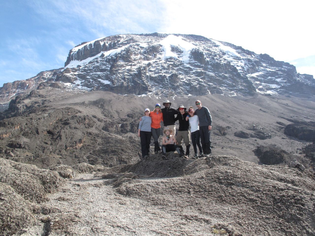 The six Americans in Brooke's group pose with guide Dismass in front of majestic Kilimanjaro.