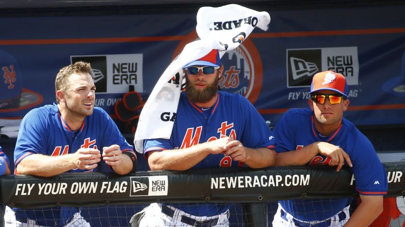 Wind blows a towel off New York Mets left fielder Kirk Nieuwenhuis as he watches a spring training game Thursday, March 12, in Port St. Lucie, Florida.