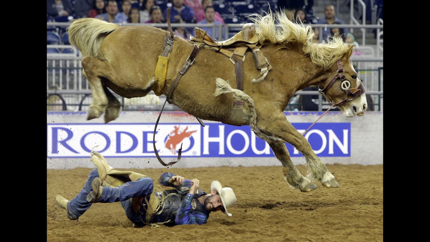 Will Smith rolls out of the way after being bucked off a bronco during RodeoHouston on Sunday, March 15.