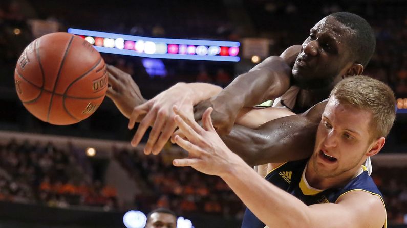 Michigan's Max Bielfeldt, bottom, and Illinois' Nnanna Egwu battle for a rebound during a Big Ten tournament game Thursday, March 12, in Chicago.