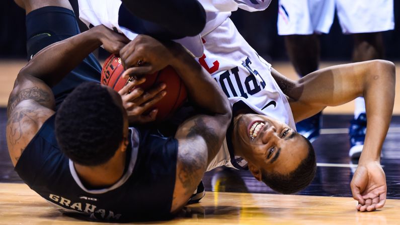 Richmond's ShawnDre' Jones, right, and VCU's Treveon Graham wrestle for the ball during an Atlantic 10 tournament game Friday, March 13, in New York.