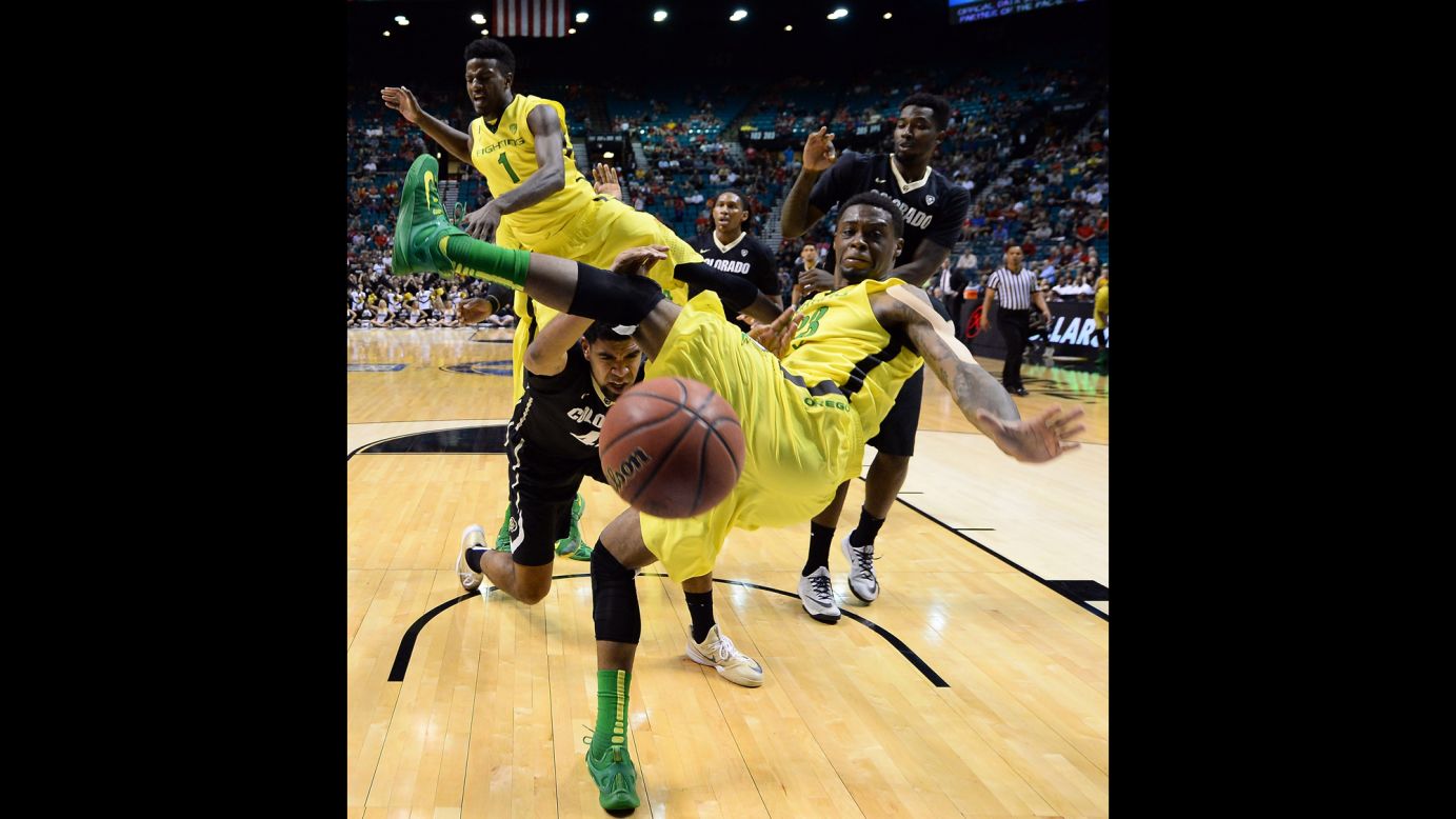 Oregon's Elgin Cook, foreground, loses his balance while defending the basket Thursday, March 12, during a Pac-12 tournament game against Colorado.