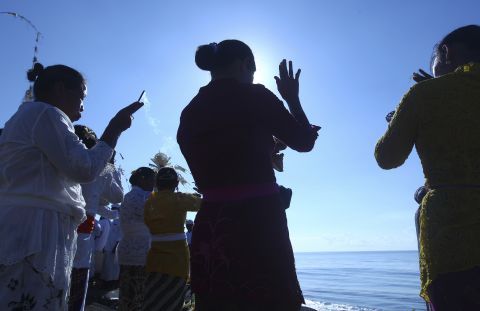 MARCH 17 - BALI, INDONESIA: Women offer prayers during a religious ceremony called Melasti. The ritual, in which the faithful carry a holy Hindu symbol to the sea to be purified, is performed ahead of the Hindu Day of Silence.