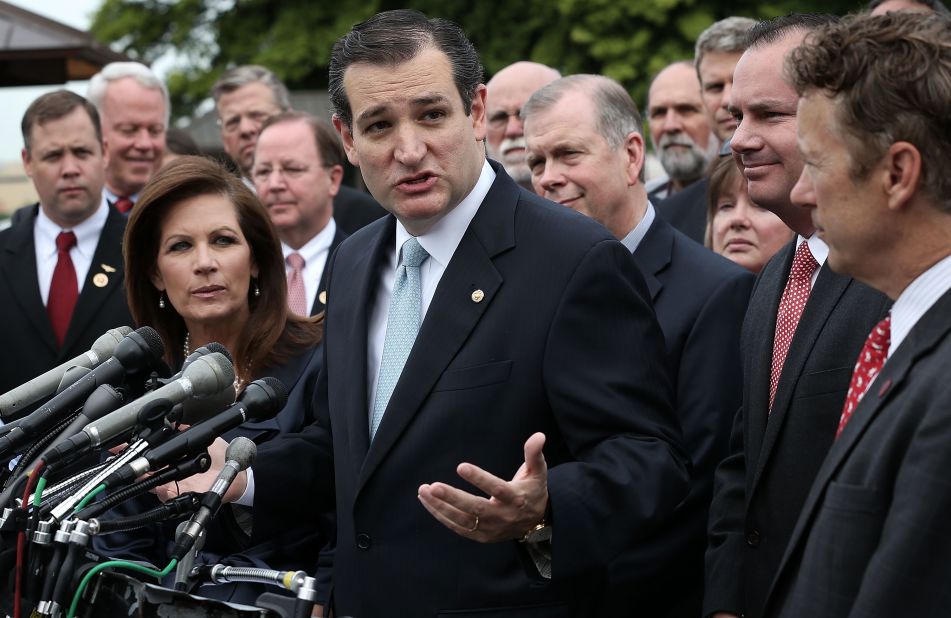 Cruz speaks as then-Rep. Michele Bachmann (left), Sen. Mike Lee (second right) and Sen. Rand Paul (right) listen during a news conference May 16, 2013, on Capitol Hill.