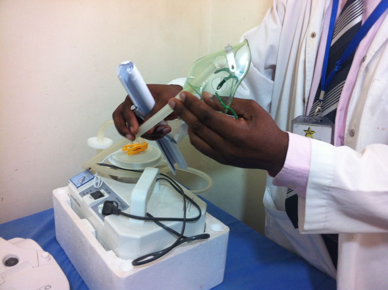 Sputum induction involves the use of a nebulizer and tubing to stimulate sputum production within a child's larynx to then suck it up for sampling.