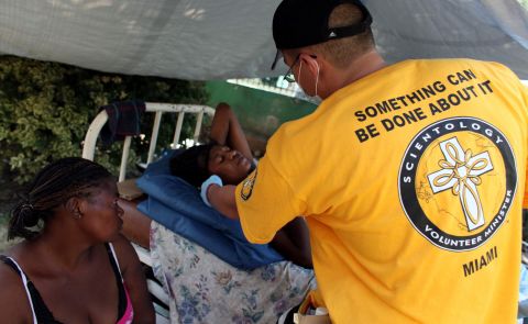 A volunteer from the Church of Scientology touches an injured woman in Port-au-Prince, Haiti, after the devastating earthquake there in January 2010.